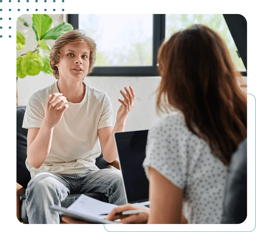 Teenager talking to a therapist in office.