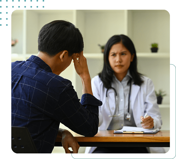 Patient consulting with a doctor at desk.