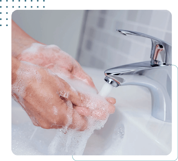 Hands washing with soap under faucet.