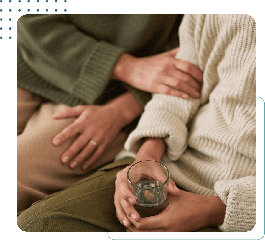 Two people sitting with comforting embrace.