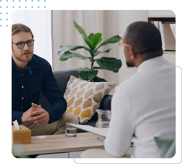 Two men talking in a living room.