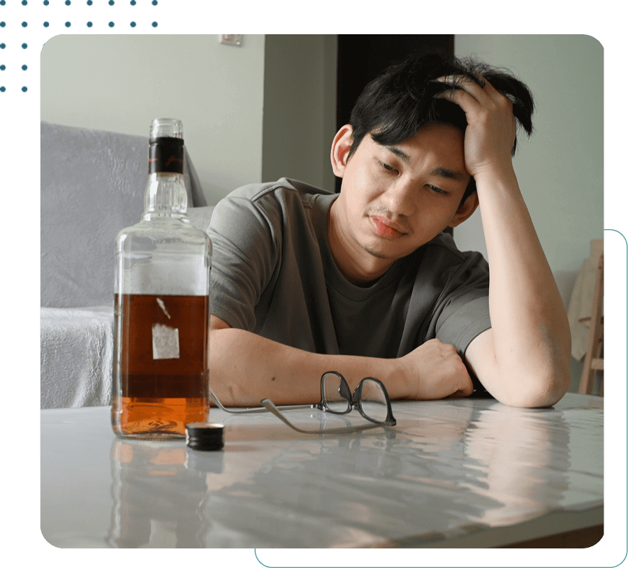 Man contemplating a bottle of alcohol.