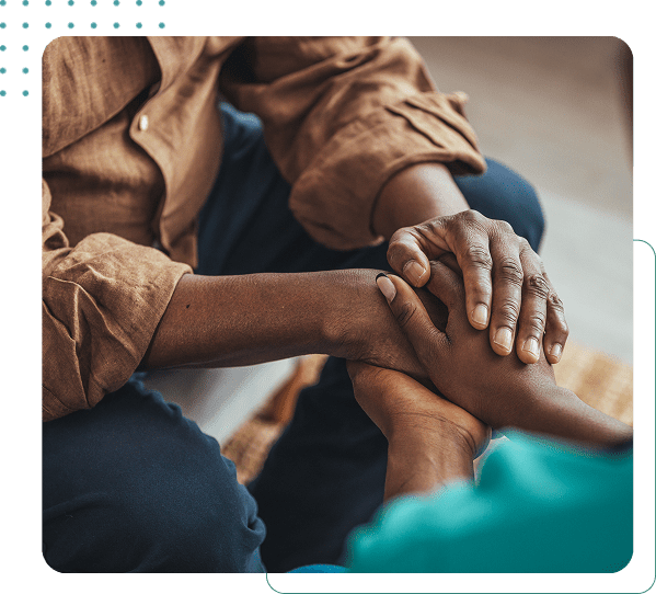 Two people holding hands for comfort.