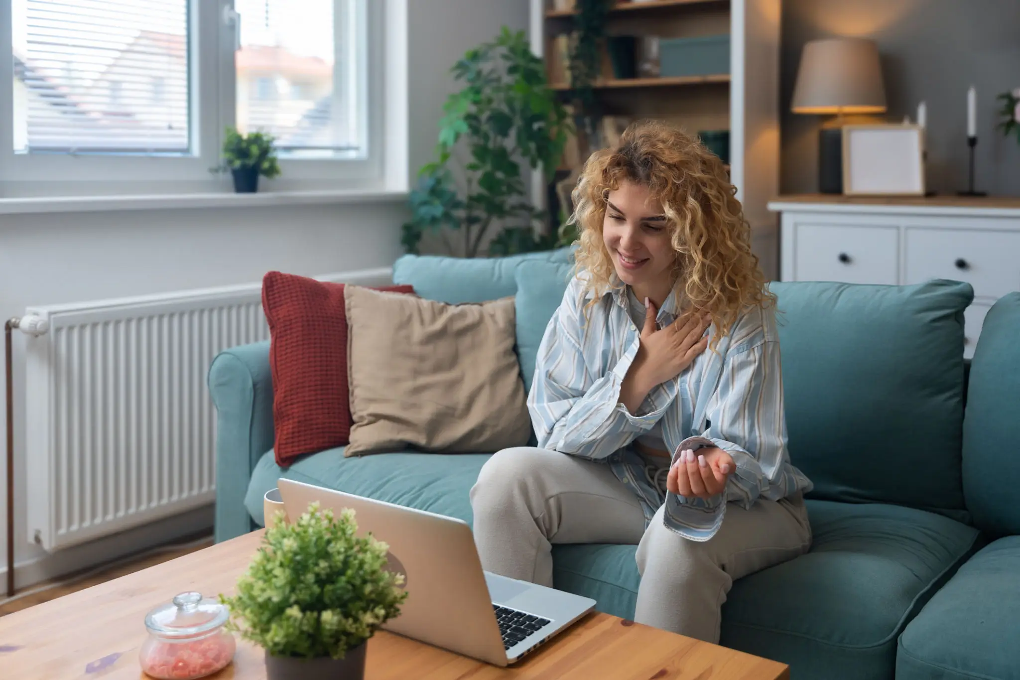 Woman video chatting on laptop at home.